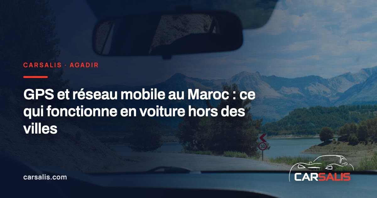 Smartphone fixé sur un support de tableau de bord, carte affichée, devant une route goudronnée de montagne dans l'arrière-pays d'Agadir